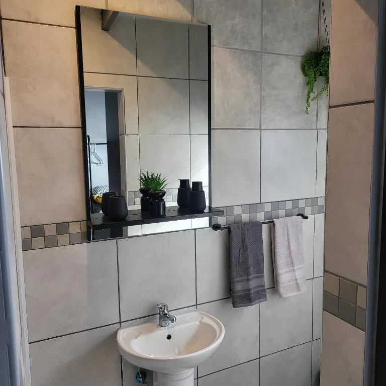 Modern bathroom vanity with pedestal sink and large mirror
