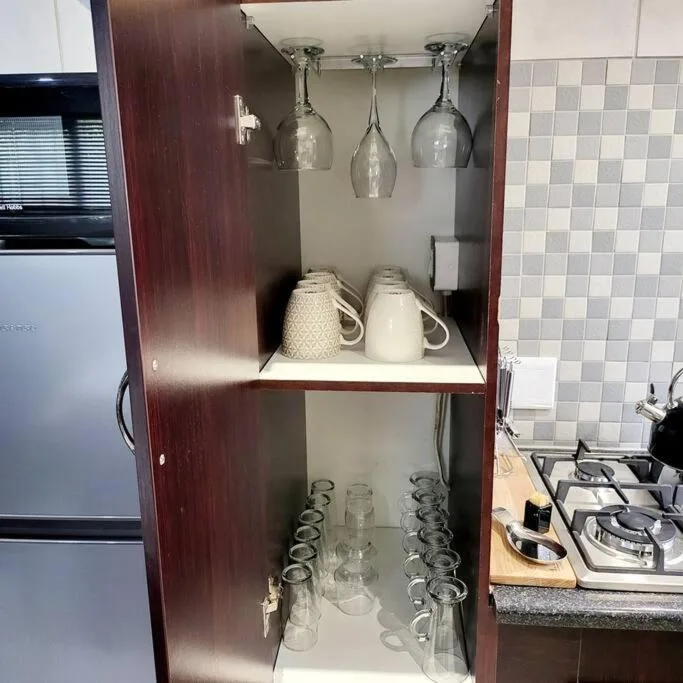 Kitchen cabinet display with wine glasses, mugs, and drinking glasses