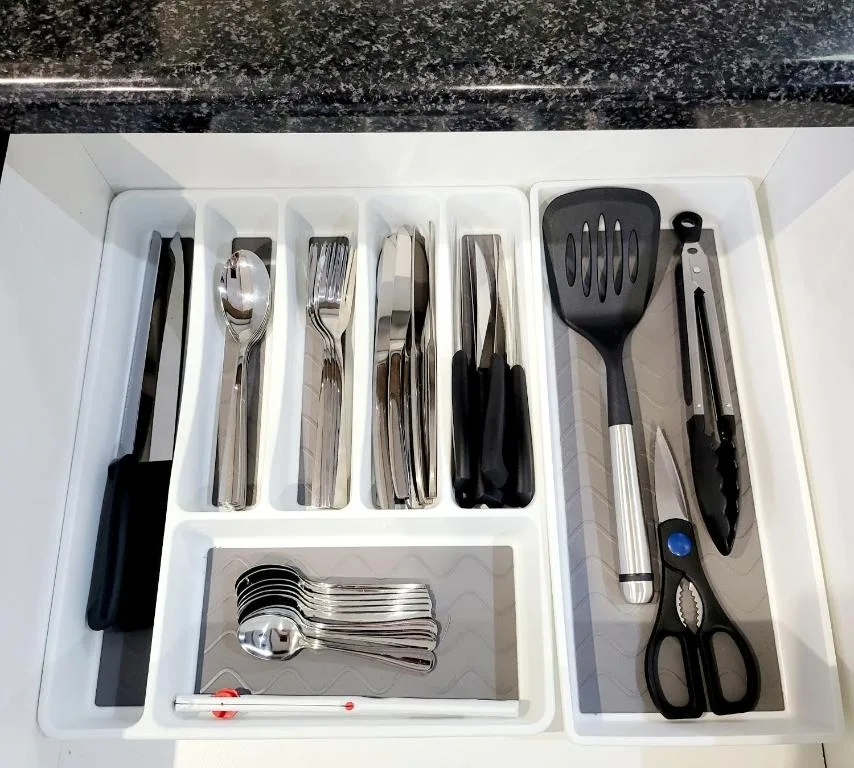 Organized kitchen drawer with cutlery, utensils, and cooking tools
