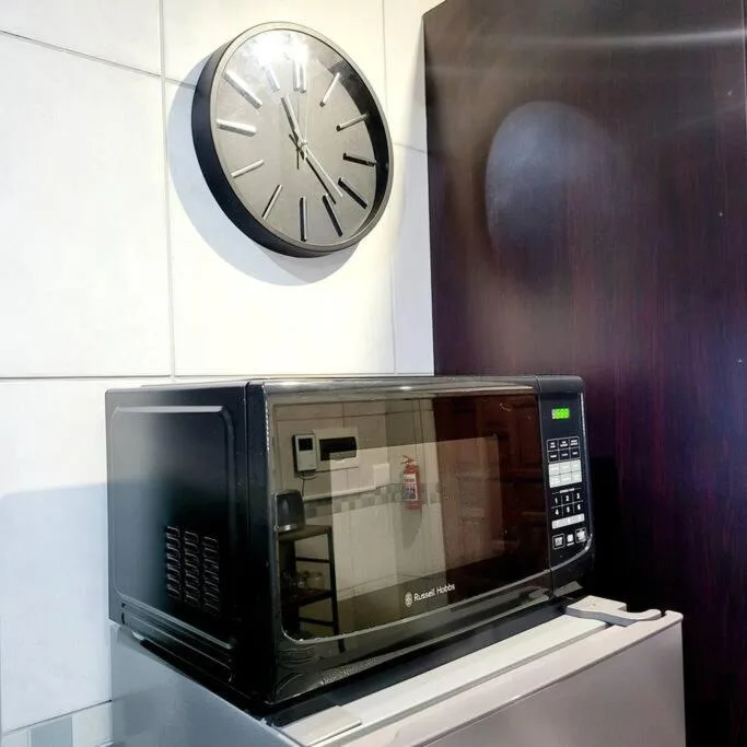 Modern microwave and wall clock in kitchen area