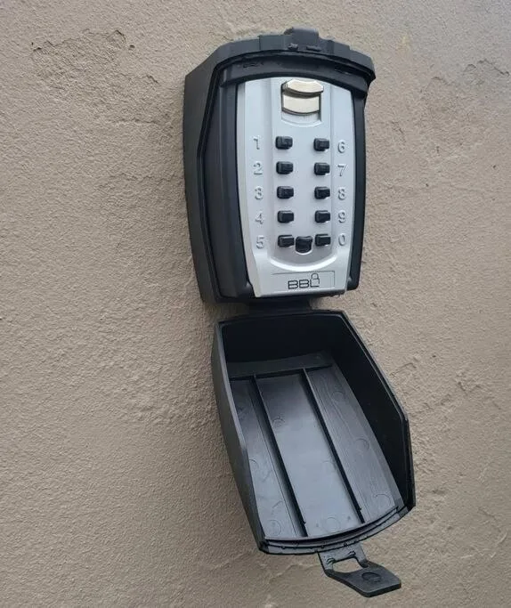 Keypad security lock mounted on cream-colored exterior wall