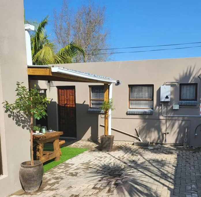 Modern beige cottage exterior with black-framed windows and wooden entrance door