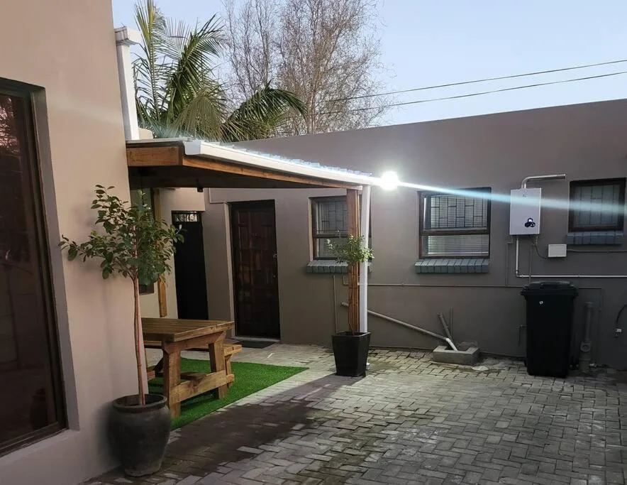 Modern studio apartment courtyard with paved patio and potted plants