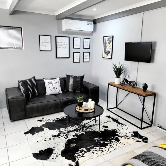Modern black and white lounge with sofa, TV, and minimalist decor