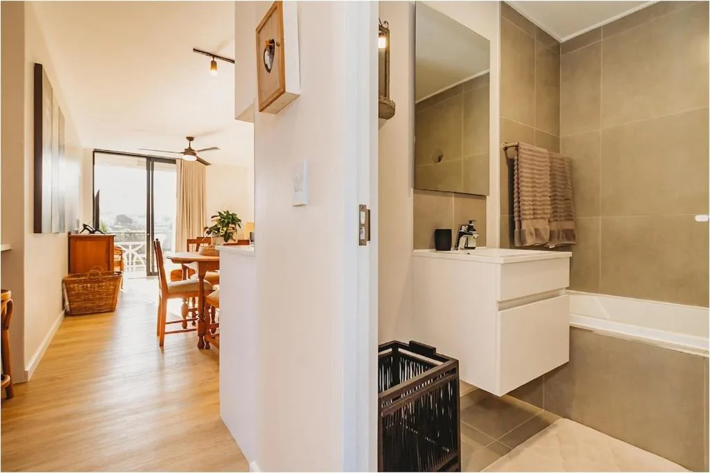 Modern bathroom with vanity, mirror, towel rack, and shower enclosure