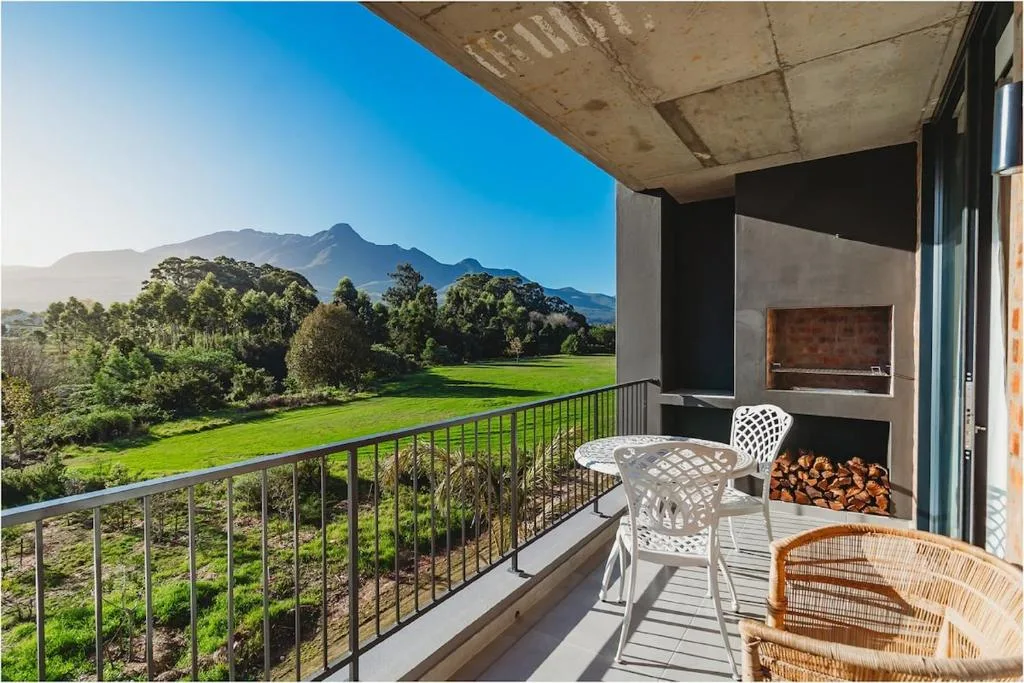 Mountain-view deck with seating, fireplace, and lush valley landscape beyond