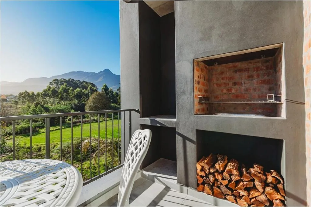 Outdoor deck with fireplace overlooking mountains and green valley landscape