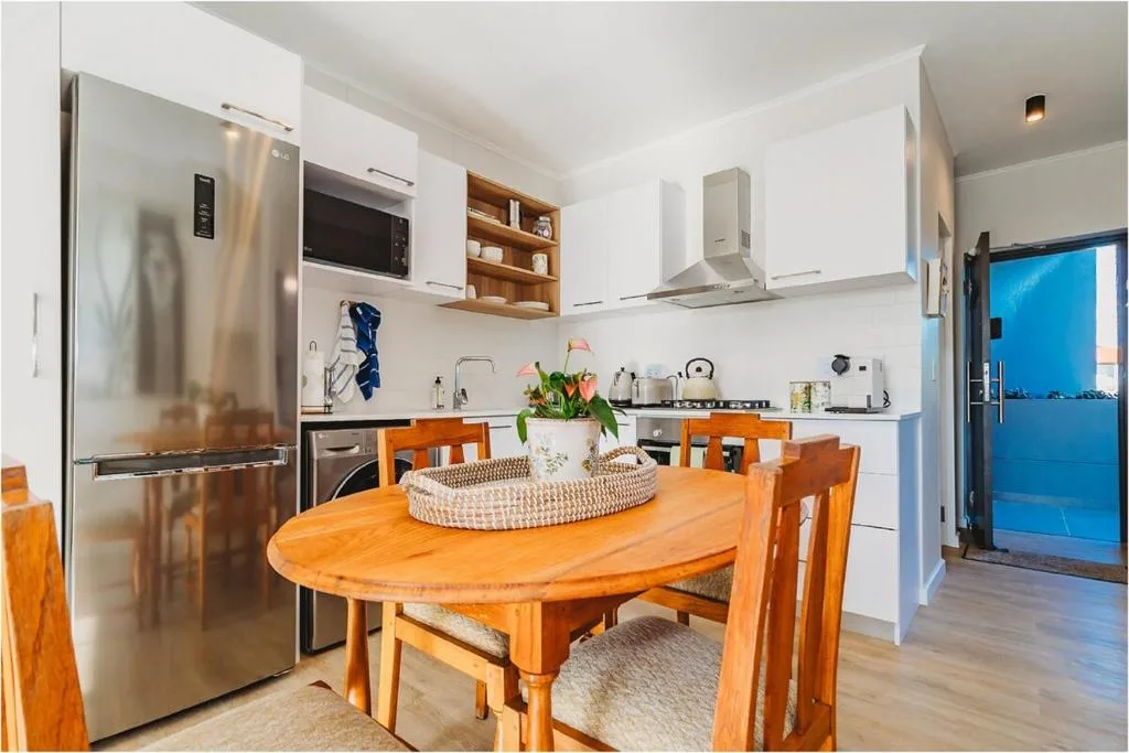 Modern kitchen with stainless steel appliances and wooden dining table