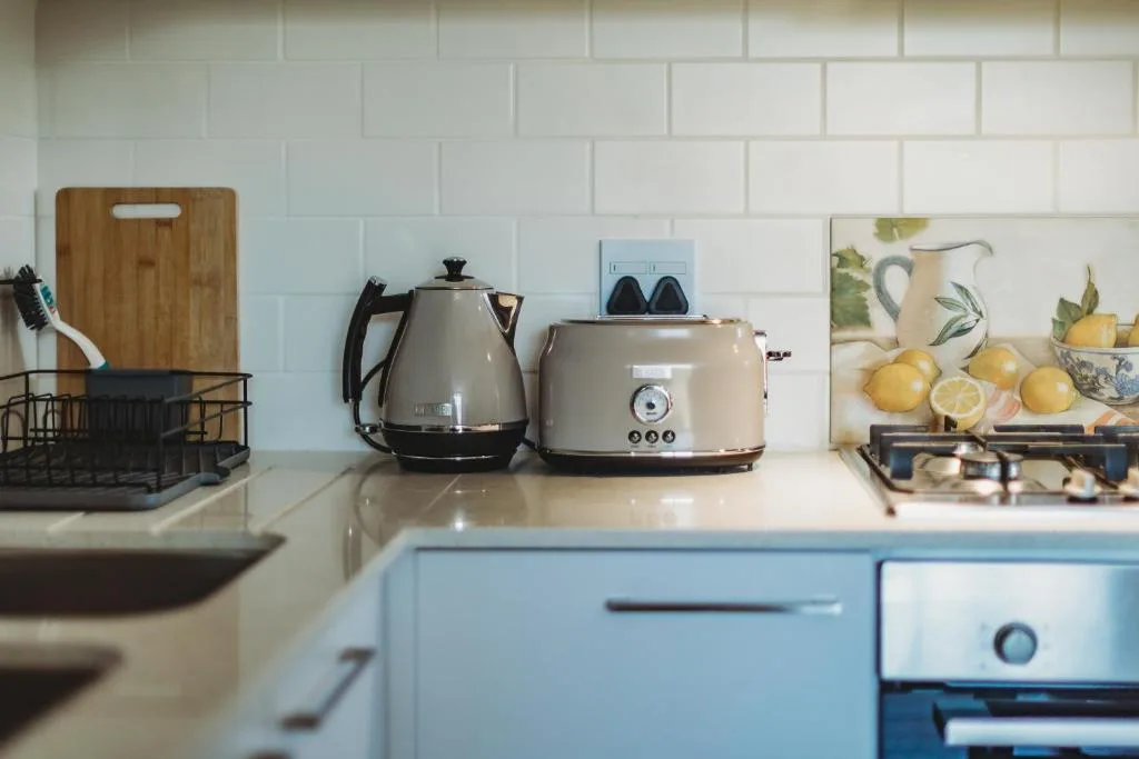 Modern kitchen counter with kettle, toaster, and decorative lemon artwork