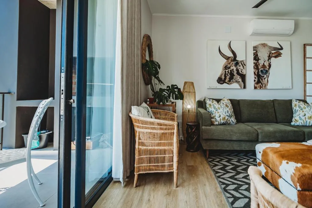 Modern lounge with green sofa, woven chair, and contemporary cattle artwork