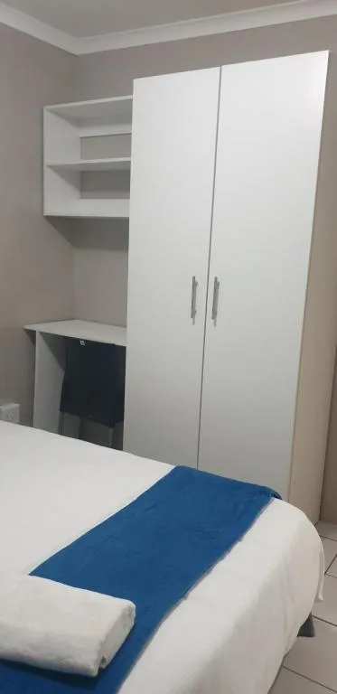 Modern bedroom with white wardrobe and built-in shelving unit