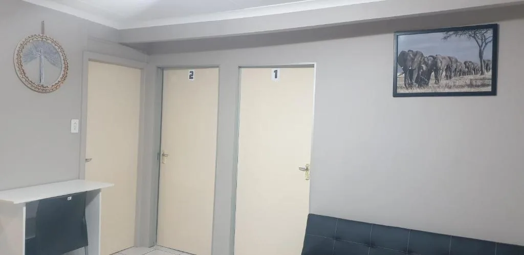 Hallway with multiple doors, clock, and elephant artwork on wall