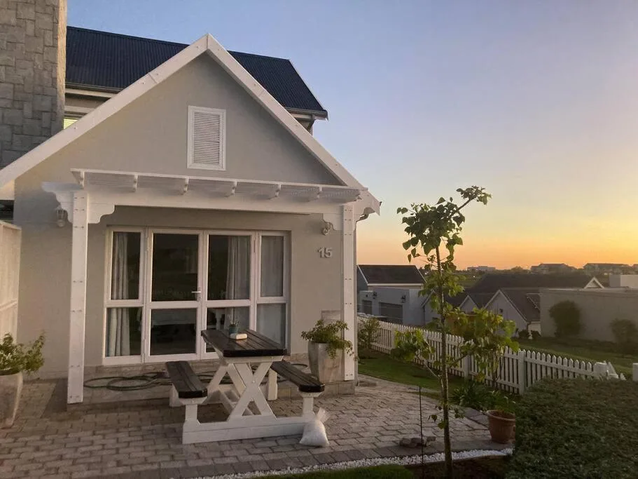 Modern white cottage with deck seating at sunset, Kingswood Golf Estate