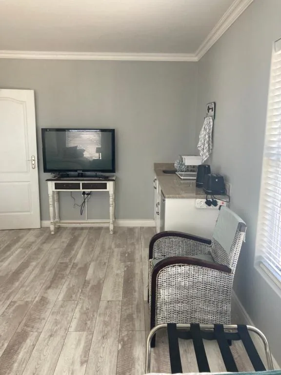 Bright lounge with wall-mounted TV on stand and comfortable seating area