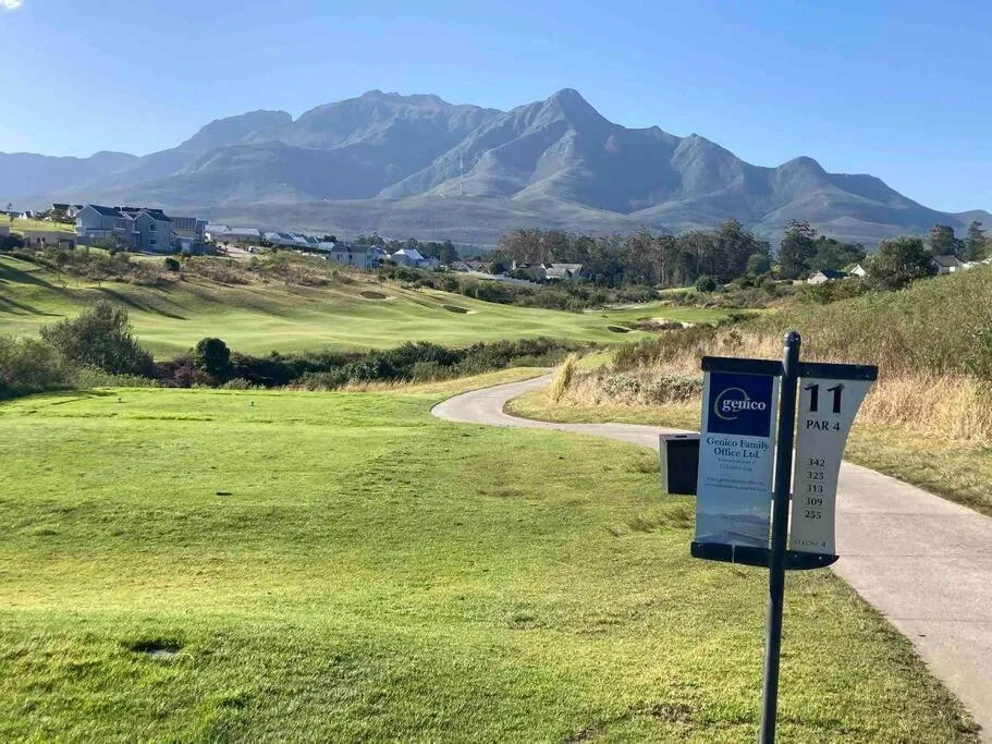 Dramatic mountain backdrop overlooking rolling golf course fairways and valley