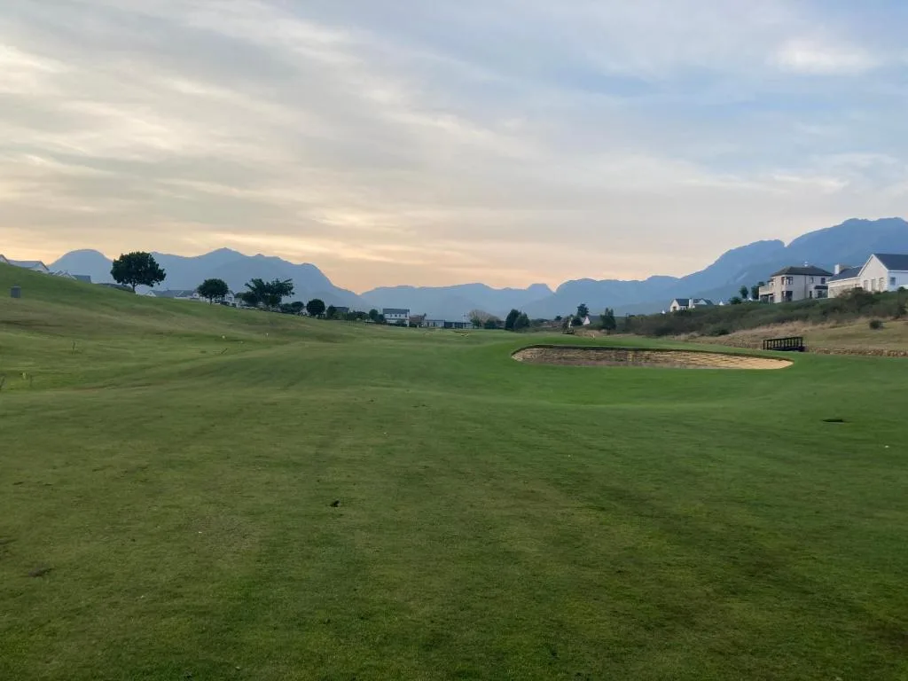 Dramatic mountain vista over manicured golf course greens and fairways