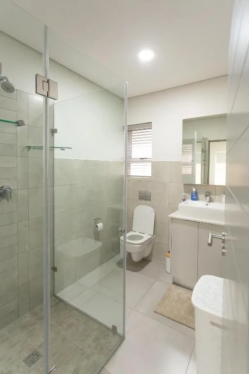 Modern bathroom with glass shower enclosure and white vanity sink