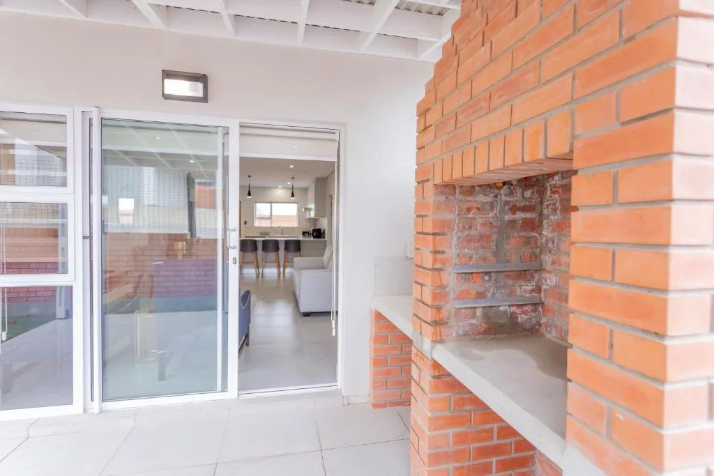 Brick braai area with white sliding doors opening to interior spaces