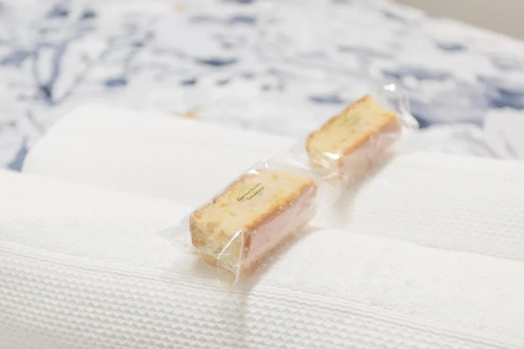 Two wrapped biscuits placed on white bedding with blue pattern