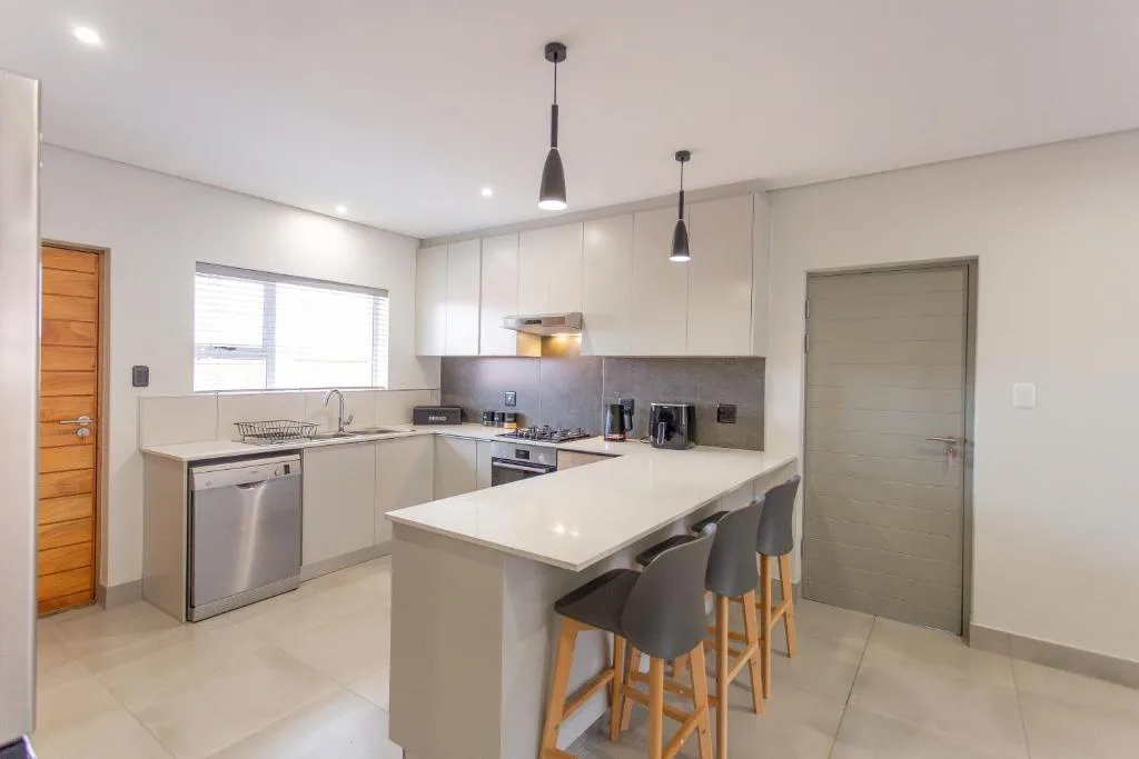 Modern kitchen with white cabinetry, island counter, and stainless steel appliances