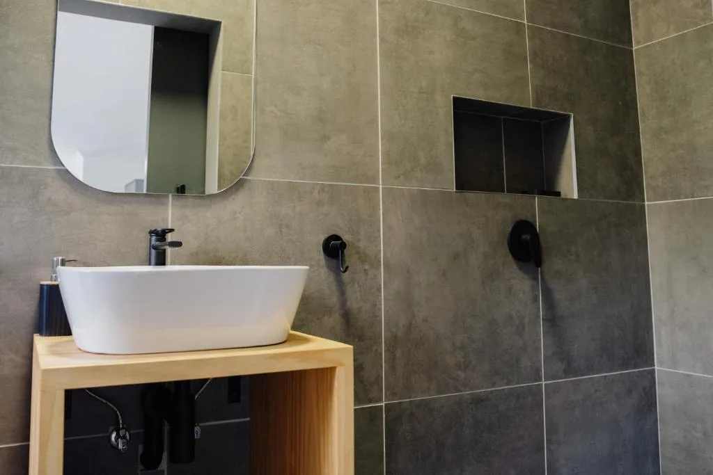 Modern bathroom with white vessel sink and wooden vanity unit