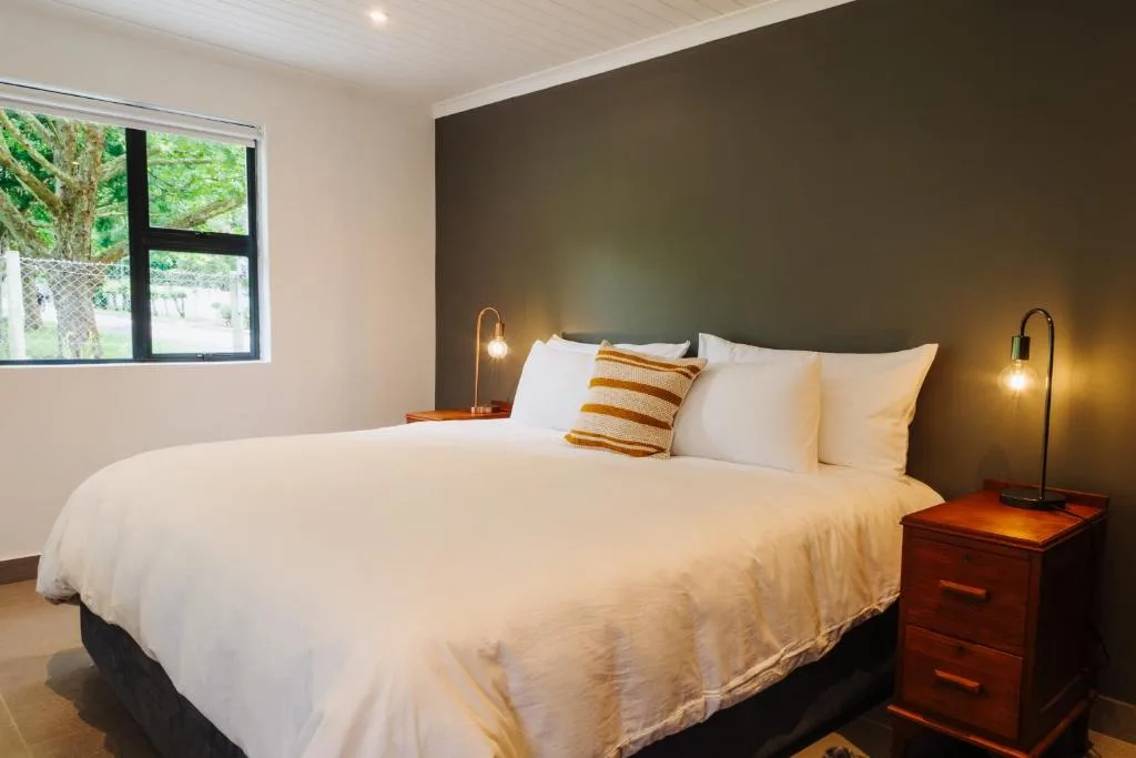 Modern bedroom with queen bed, white linens, and olive accent wall
