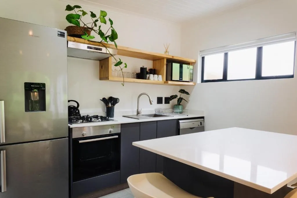 Modern kitchen with black cabinetry, gas stove, and white countertop island