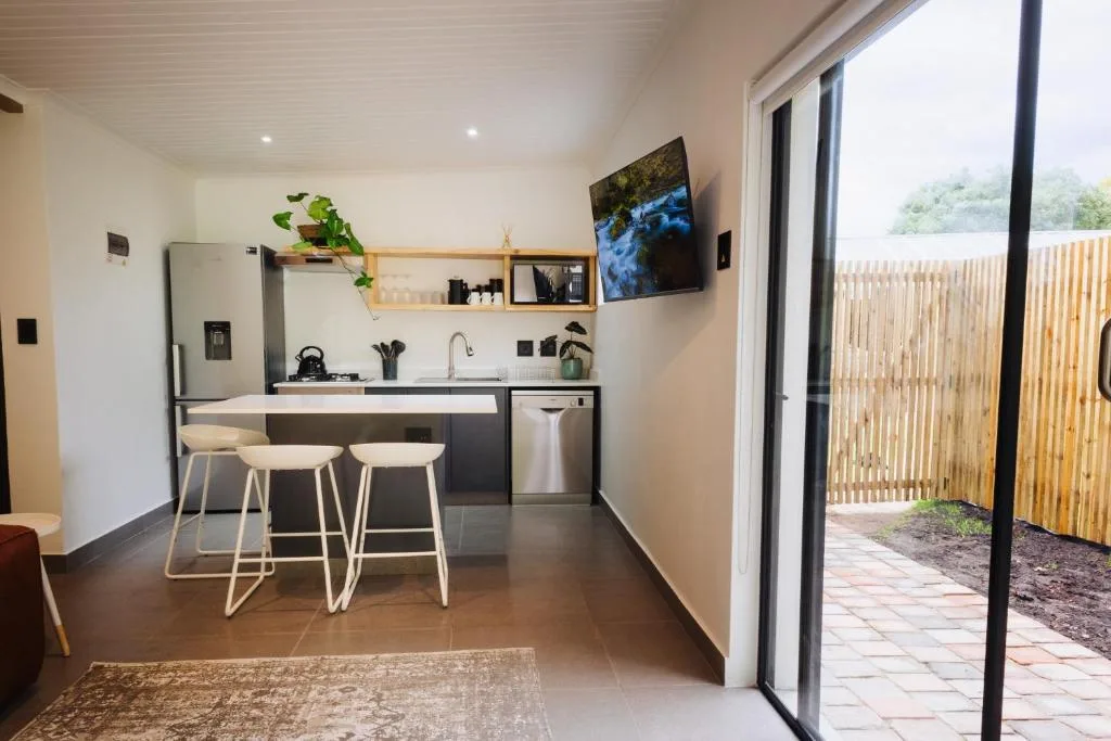 Modern kitchen with island seating, stainless appliances, and garden view