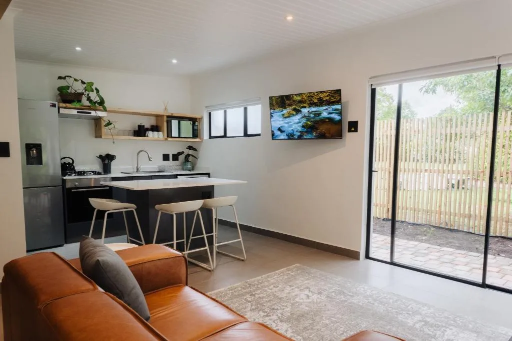 Open-plan lounge with orange leather sofa and kitchen island seating area