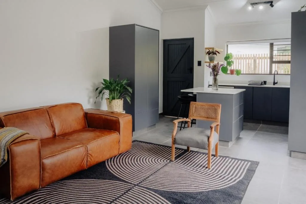 Modern lounge with cognac leather sofa and open kitchen connection