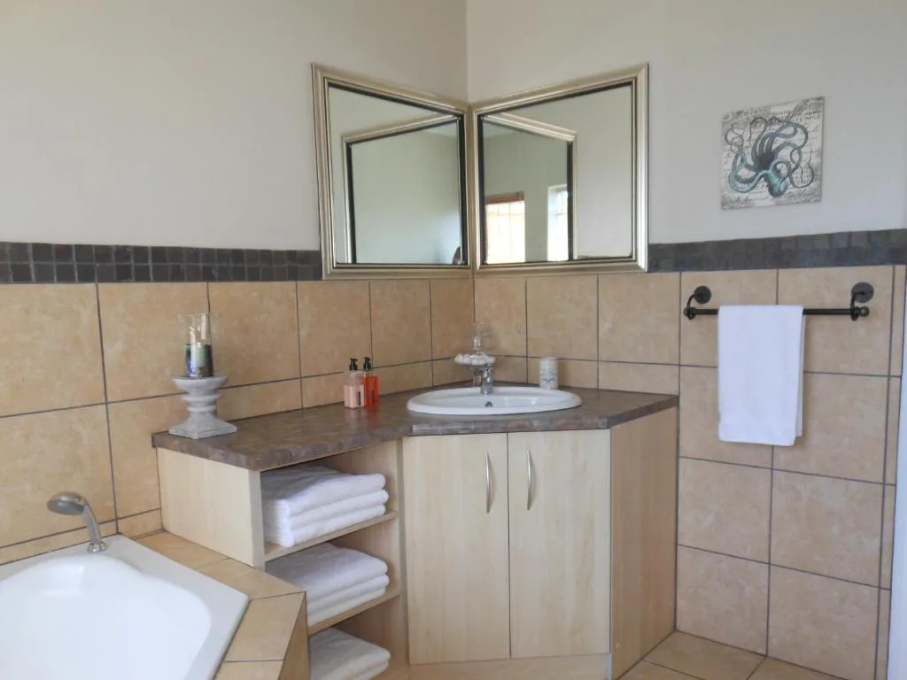 Spacious bathroom with dual sink vanity, mirrored cabinet, and tiled walls