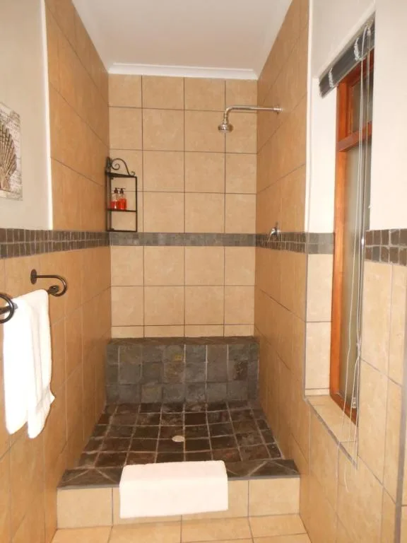 Walk-in shower with terracotta tiles and rainfall showerhead fixture