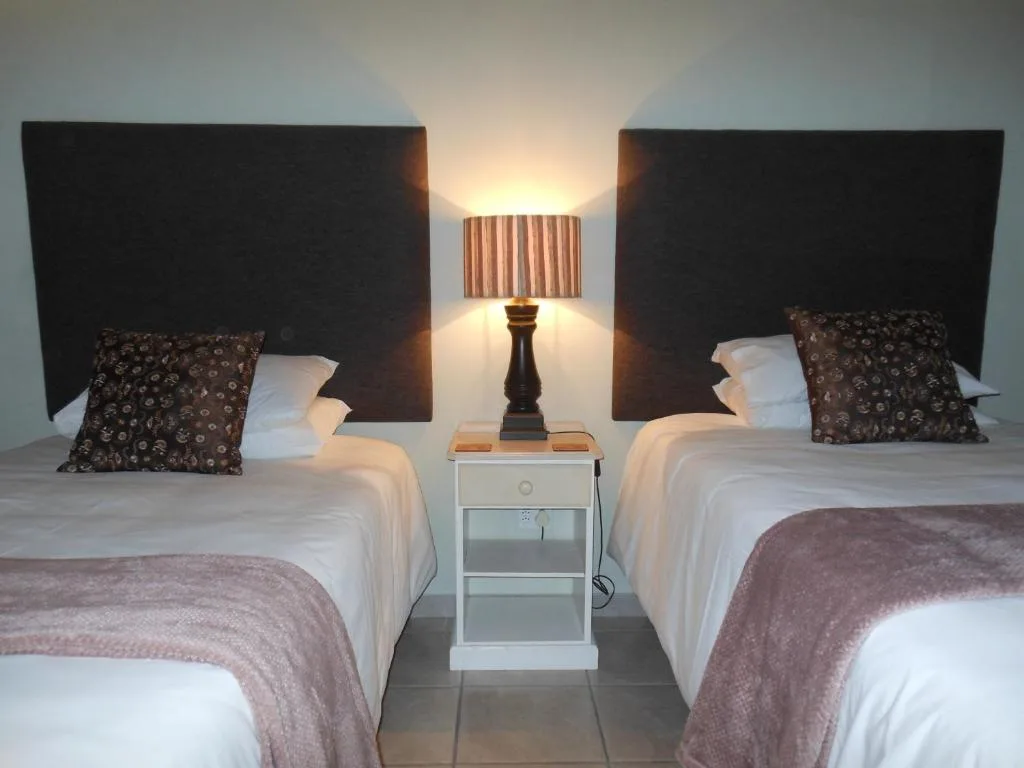 Twin beds with white linens and patterned pillows, contemporary headboards
