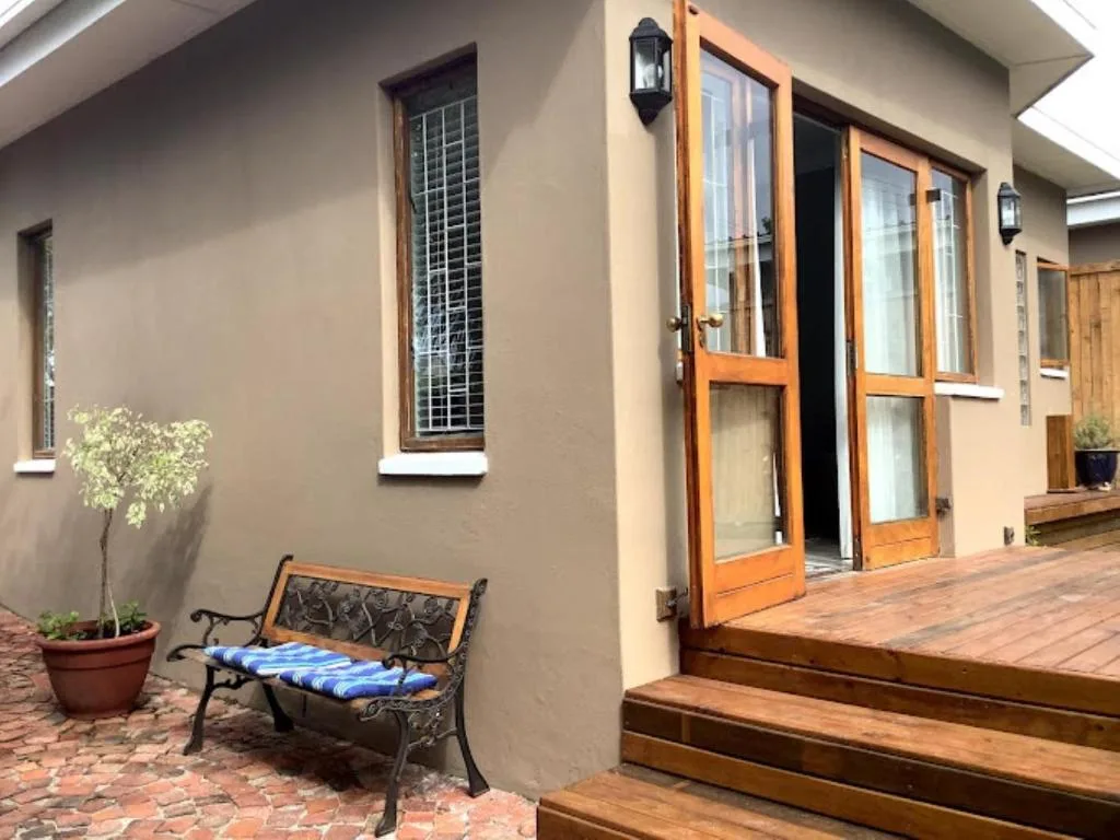 Wooden deck and patio area with seating bench and potted plant