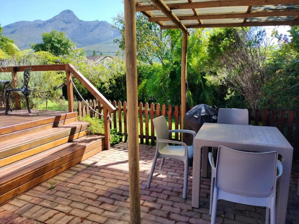 Wooden pergola deck with dining table overlooking mountain views