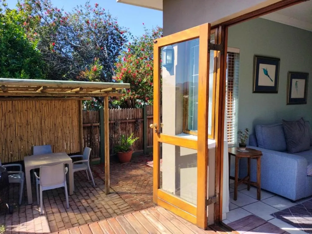 Covered patio with dining table and flowering bougainvillea plants overhead