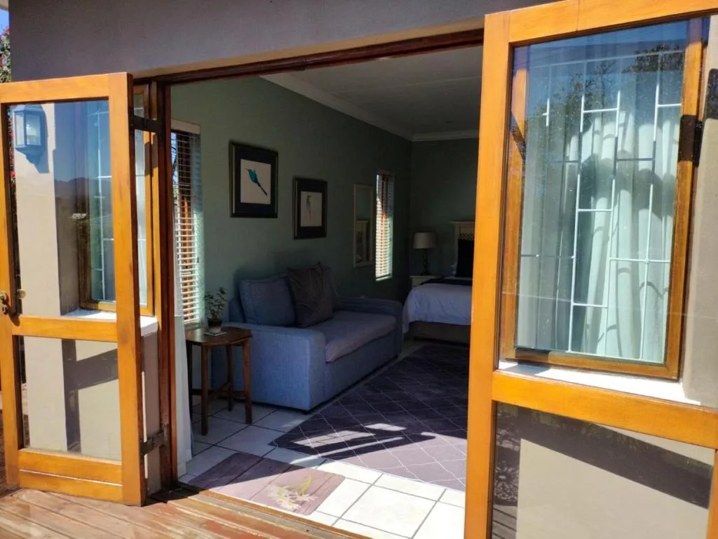 Open wooden deck with glass doors leading into bright interior space