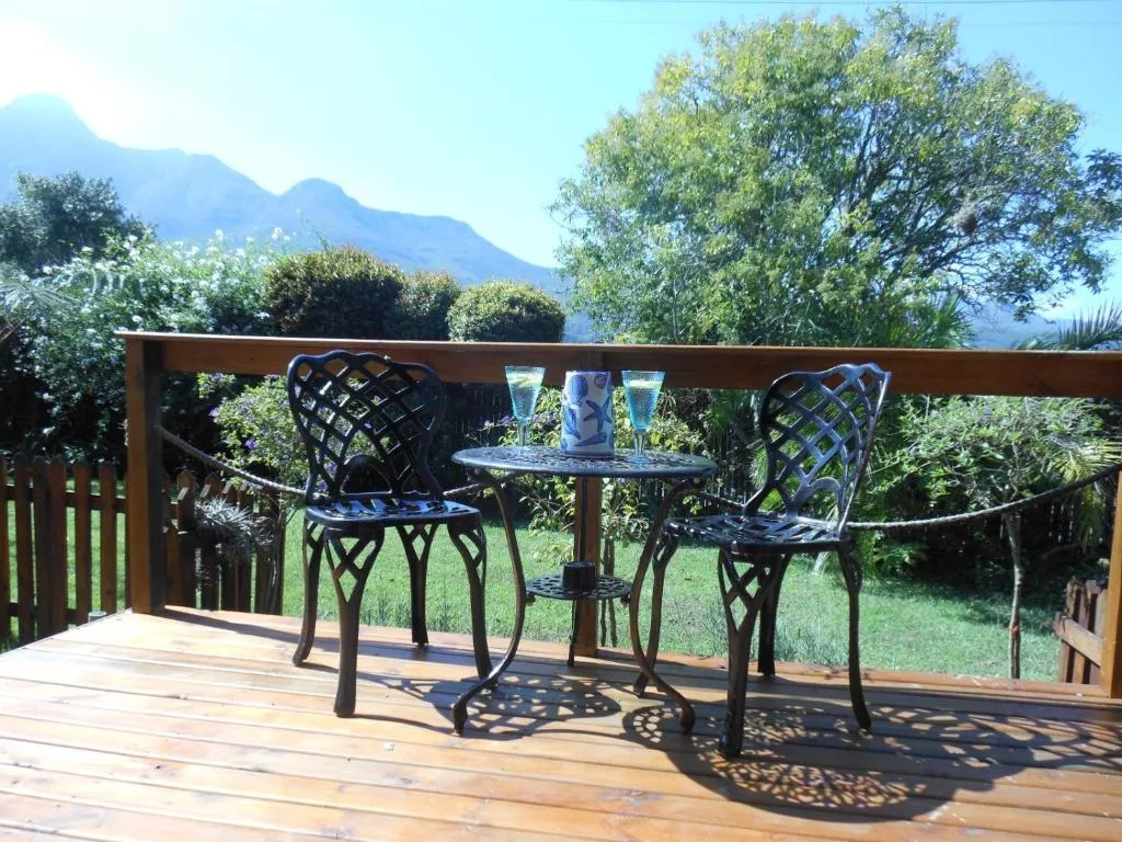 Wooden deck with black chairs and table overlooking mountain views