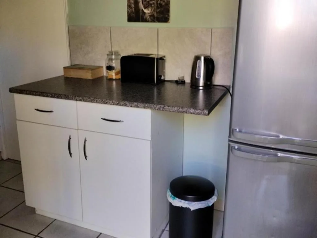 Modern kitchen with white cabinetry, dark countertop, and stainless steel appliances