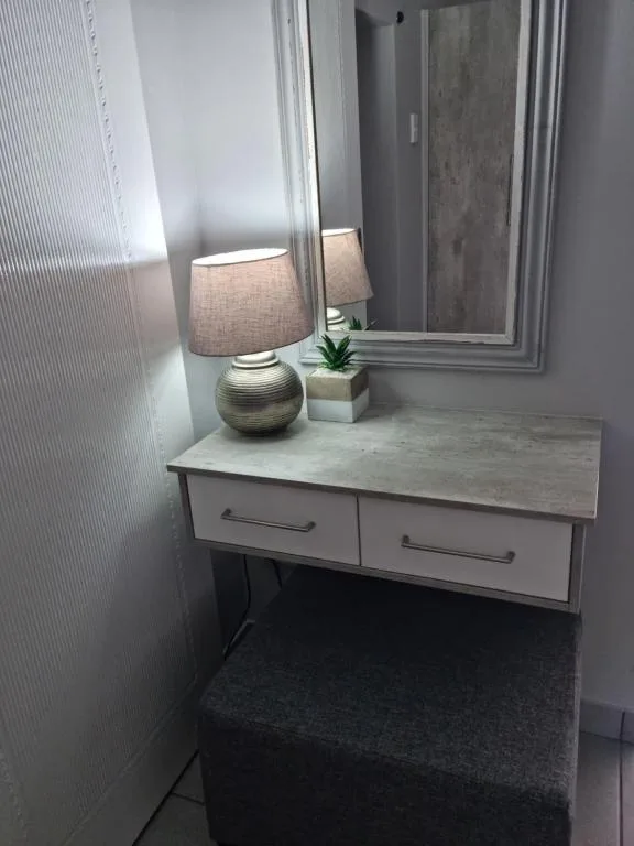 Modern bathroom vanity with lamp, mirror, and decorative plant accents