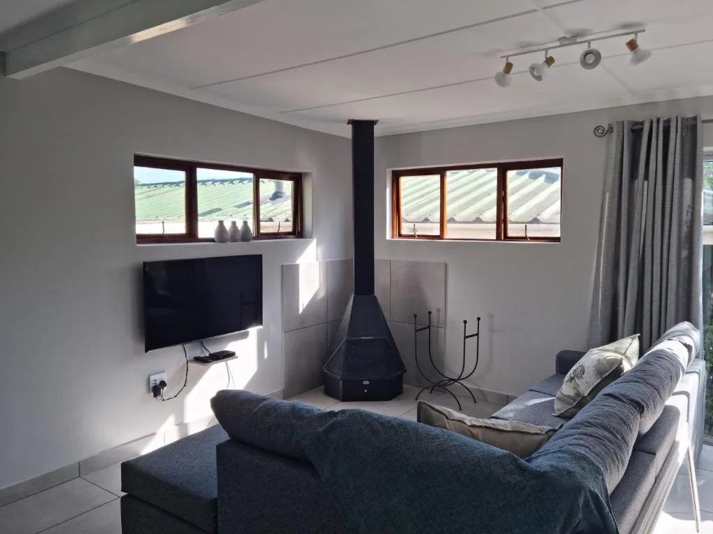 Modern lounge with sofa, fireplace, TV, and expansive countryside views