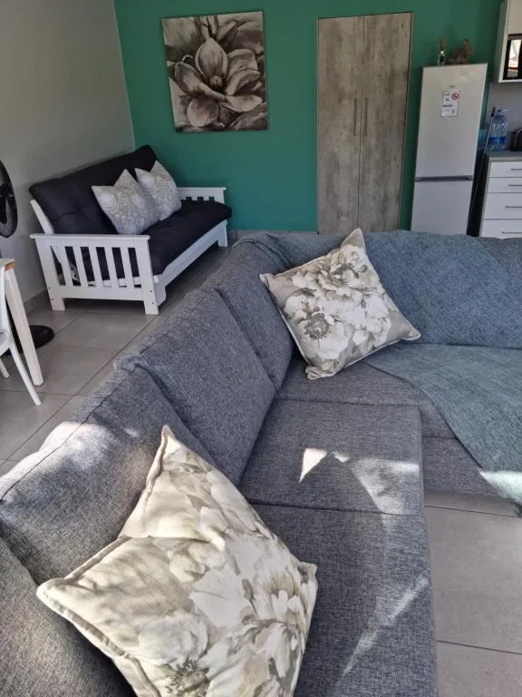 Spacious lounge with gray sofa, decorative pillows, and turquoise accent wall