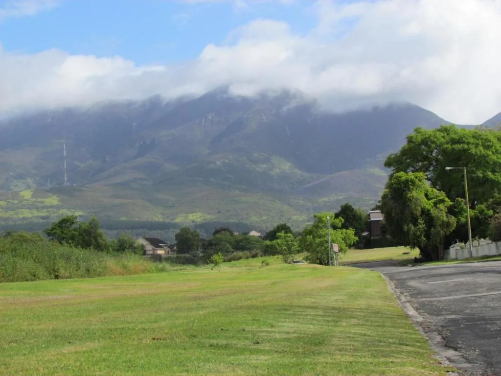 Majestic mountain range with lush green valleys and scattered properties below