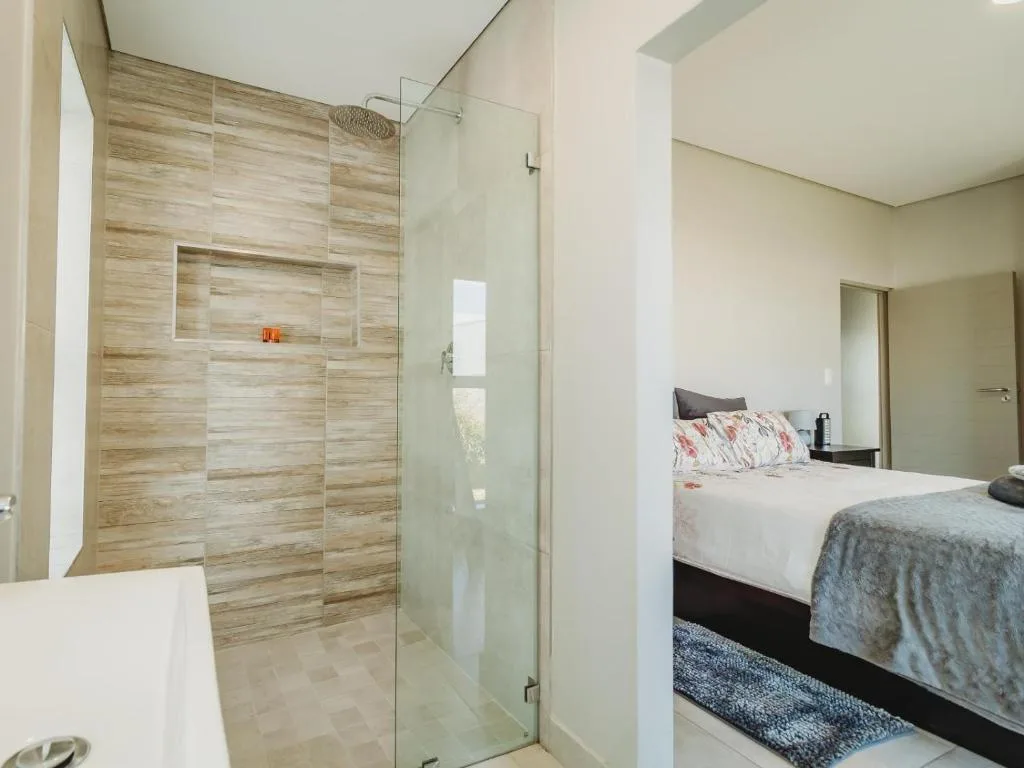Modern ensuite bathroom with walk-in shower and wood-grain tiling