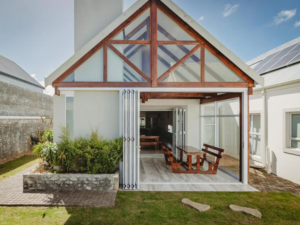 Modern covered deck with wooden beams and bi-fold doors opening to garden