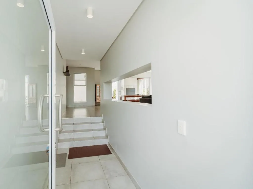 Modern hallway with tiled floors and pass-through window view