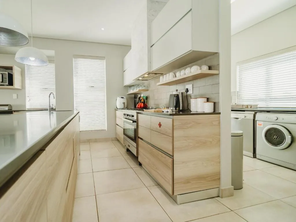 Modern kitchen with wooden cabinetry, stainless steel appliances, and open shelving