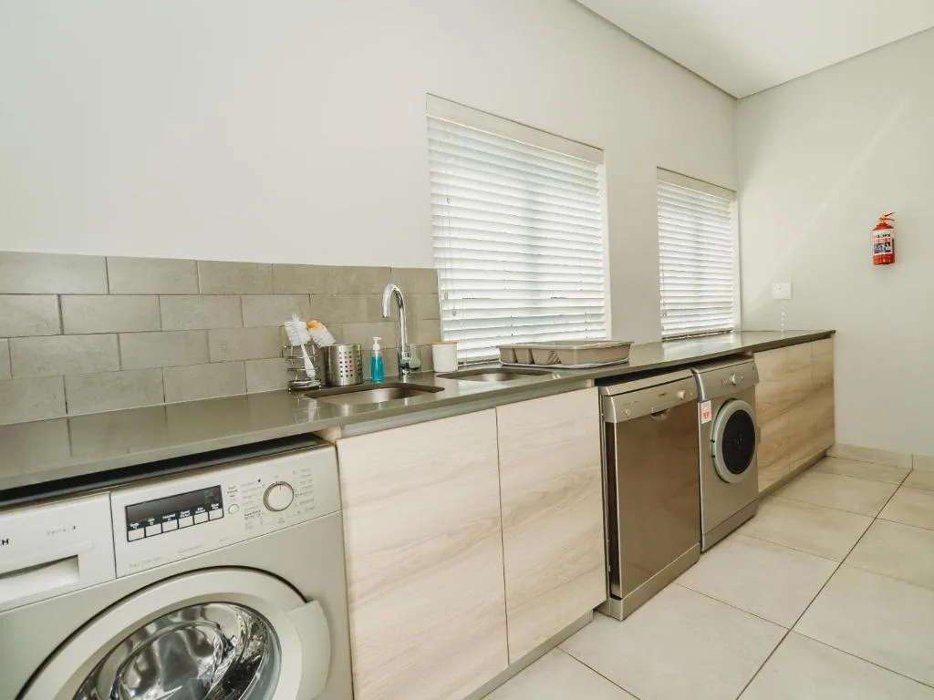 Modern kitchen with subway tile backsplash, stainless steel appliances, and washing machine