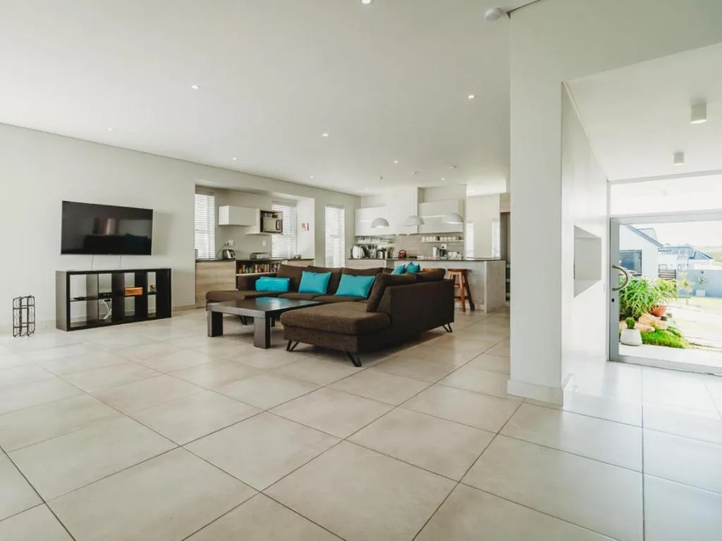 Modern open-plan lounge with brown sectional sofa and turquoise cushions