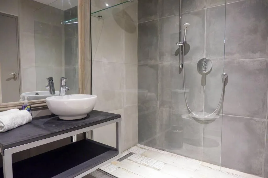 Modern bathroom with vessel sink, glass shower enclosure, and contemporary fixtures